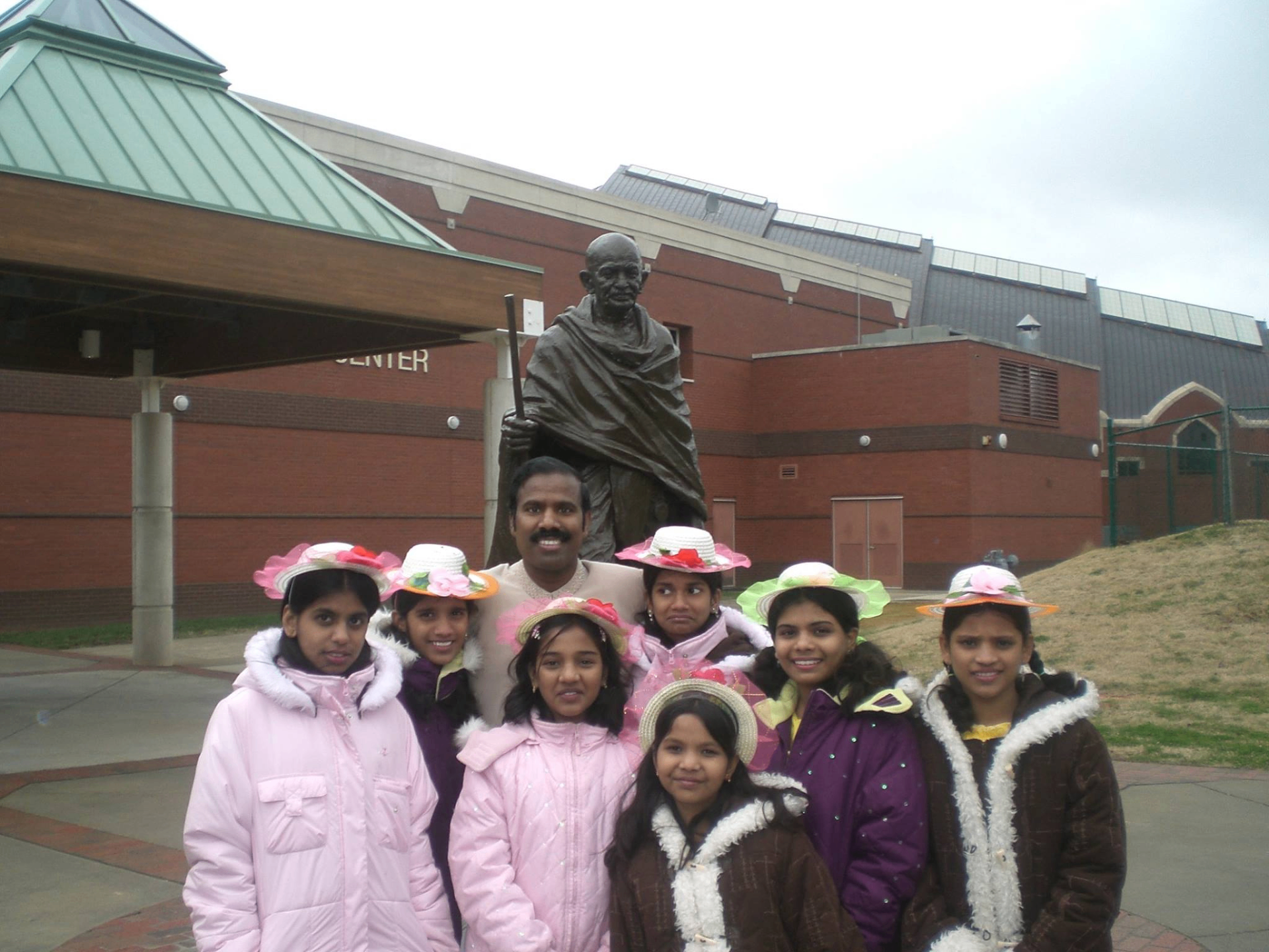 Dr. K.A. Paul with orphan children before a Mahatma Gandhi statue