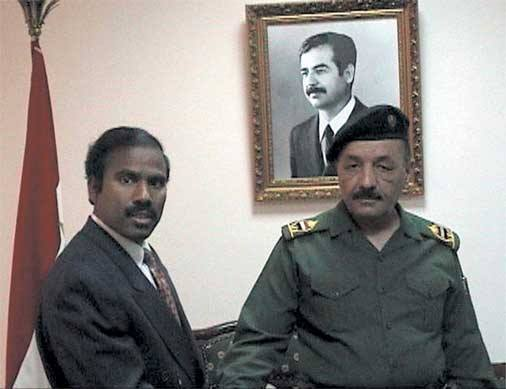 Dr. K.A. Paul with an Iraqi general beneath a portrait of Saddam Hussein, Baghdad
